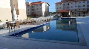 a swimming pool in front of some buildings at AP PRAIA - Cond Vog João de Góis 2 quartos com AR in Ilhéus