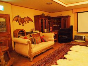 un soggiorno con divano e schermo di Petit Hotel Corinthian a Rebun