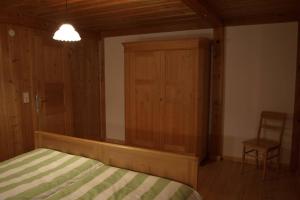 1 dormitorio con 1 cama, 1 silla y 1 armario en Großzügige Ferienwohnung am Kloster, en Kirchzarten