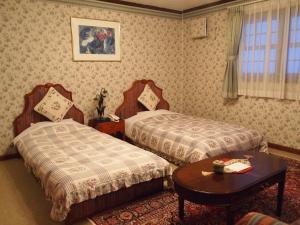 En eller flere senger på et rom på Petit Hotel Corinthian