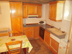 a small kitchen with wooden cabinets and a table with a tableablish at 54 AV ROGERS MARTIN DU GARD in Bellême