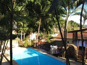 vista su una piscina con palme di ILHABEACH Suítes e Chalés a Ilhabela Altre 75 foto