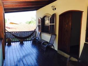 una veranda con sedie e amaca su una casa di ILHABEACH Suítes e Chalés a Ilhabela