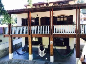 una casa con un portico con altalena di ILHABEACH Suítes e Chalés a Ilhabela