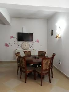 a dining room with a table and chairs and a tv at Vila Nicoleta in Băile Olăneşti