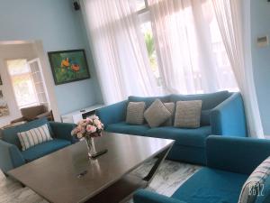 a living room with blue couches and a coffee table at LuxSea Villa in Phan Thiet