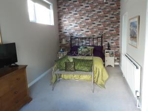 ein Schlafzimmer mit einem Bett und einer Ziegelwand in der Unterkunft Greencastle B&B in Kilkeel
