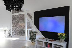sala de estar con TV de pantalla plana grande en la pared en Ferienwohnung Villa Ruhr, en Mülheim an der Ruhr