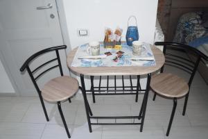 a table with two chairs and a table with two cups at affittacamere BABY in La Spezia