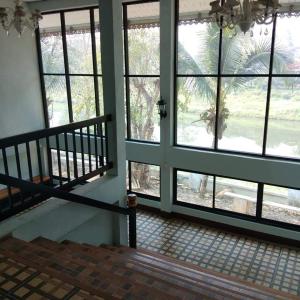 Habitación vacía con ventanas grandes y escalera. en Wangtong Resort 2 en Ban Huai Salok