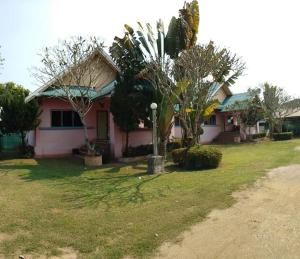 a pink house with trees in the yard at Wangtong Resort 2 in Ban Huai Salok