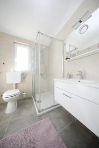 e bagno con doccia, servizi igienici e lavandino. di Apartments Noa Nin Ždrijac a Nin