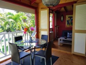 a dining room with a glass table and chairs at Villa & Bungalow Fleur de Coco in Sainte-Anne