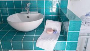 a green tiled bathroom with a sink and towels at Villa Calò in Castelvetrano Selinunte +62 photos