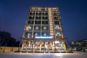 a tall building with lights on it at night at HOTEL SILVERA GRAND in Ahmedabad