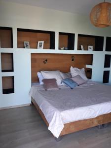a bedroom with a large bed with a wooden headboard at LA MAISON DES JADES in La Saline les Bains +17 photos