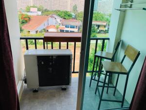 einen Balkon mit Heizung sowie einem Tisch und Stühlen in der Unterkunft Spa Guest House in Jomtien Beach