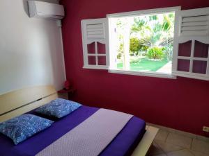 1 dormitorio con cama y ventana en Villa & Bungalow Fleur de Coco, en Sainte-Anne