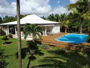 a house with a swimming pool in the yard at Villa & Bungalow Fleur de Coco in Sainte-Anne