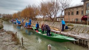 un grupo de personas en un barco verde en un río en Agriturismo La Barena, en Jesolo