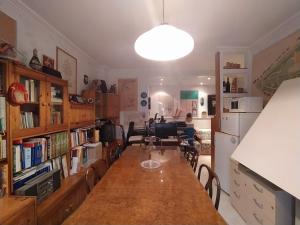 a kitchen with a long table and a living room at The Architect in Bari Palese