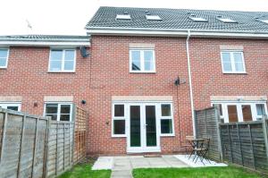 ein rotes Backsteinhaus mit einem Zaun davor in der Unterkunft Atlas House - Ideal for Contractors or Derby County Fans in Derby