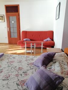 a living room with a couch and a bed with pillows at Guesthouse Sava in Slavonski Brod