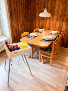 a wooden table with chairs and a wooden wall at Ferienwohnung Meiringen "Engelhorn" in Meiringen