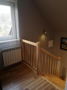 a room with a wooden staircase and a window at Domek u Basi in Grywałd