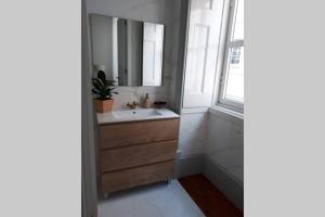 uma casa de banho com um lavatório e um espelho em Ficus Áurea em Aveiro