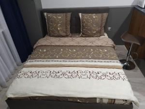 a bed with brown and white blankets and pillows at Silver Star Apartment in Uzhhorod