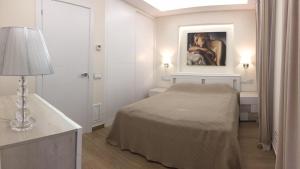 桑特费柳德吉克索尔斯Nuevo Apartamento Moderno Elisa - a 80 metros de la playa para 5 personas的白色的房间,配有一张床和墙上的绘画