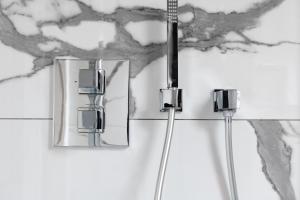a bathroom with a shower with two mirrors at Hotel Meltzer Apartments in Tallinn