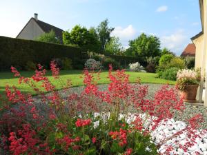 a garden with red and pink flowers in a yard at St Germain in Saint-Germain-du-Corbéis