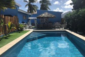 una piscina frente a una casa azul en Private Home with Pool, Outdoor Kitchen and BBQ, en Kralendijk