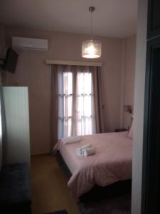 um quarto com uma cama e uma janela com toalhas em Marina's Luxury Rooms em Nafplio