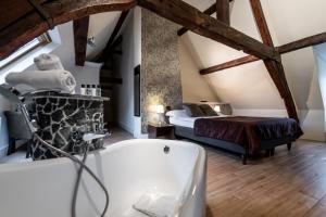 un bagno con vasca e un letto di Hotel Onderbergen a Gand