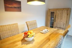 a bowl of fruit sitting on a wooden table at Ferienhaus Sonnenlicht - Familien und Kiter "Willkommen" in Fehmarn