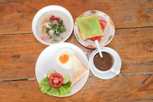 een tafel met drie borden eten en een kop koffie bij C Tower Hotel in Suratthani