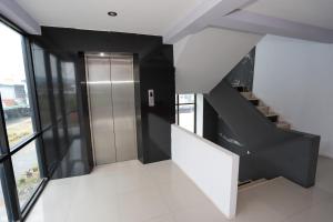 a staircase in a building with a elevator at C Tower Hotel in Suratthani