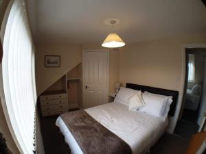 a small bedroom with a bed and a window at 4 Bedroom House in Weymouth