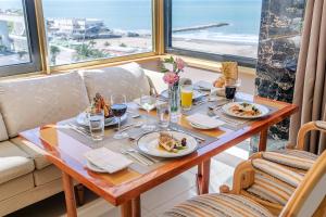 a table with plates of food on it with a view of the ocean at Hotel Costa Galana in Mar del Plata