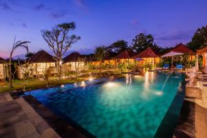 una piscina en un complejo por la noche en D'Coin Lembongan, en Nusa Lembongan
