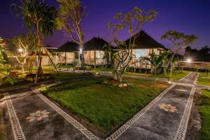 a villa with a garden at night at D'Coin Lembongan in Nusa Lembongan
