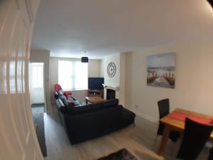 uma sala de estar com um sofá e uma mesa em 4 Bedroom House em Weymouth