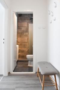 a bathroom with a toilet and a stool in it at Pannonian sailor in Novi Sad +16 photos