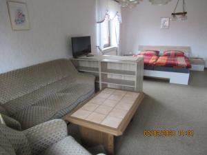 a living room with a couch and a bed at Ferienwohnung "Romaker" in Jeersdorf