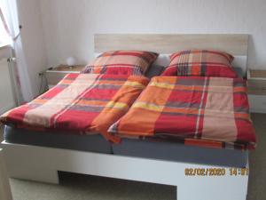 a bed with colorful blankets and pillows on it at Ferienwohnung "Romaker" in Jeersdorf