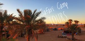 Sahara Luxury Camp M'hamid في Mhamid: شاطئ فيه نخيل وعلامة مكتوب عليها فندق نخيل الوادي