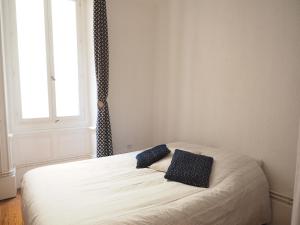 a bedroom with a bed with two blue pillows on it at Appartement le st jean - centre historique in Valence